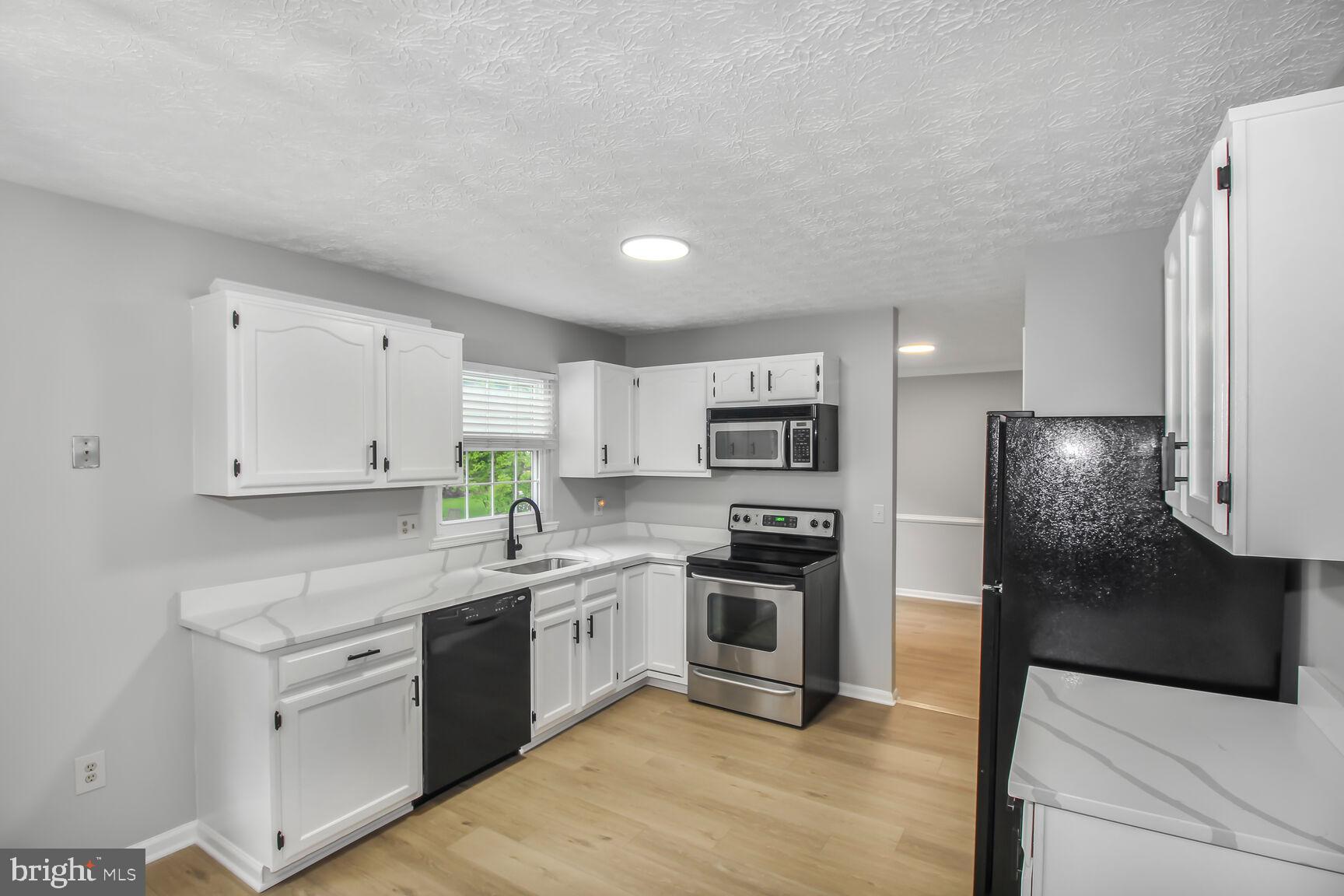 408 Sutton Place Abingdon, MD 21009 - Photo 9 of 26 a kitchen with stainless steel appliances granite countertop a refrigerator sink and stove