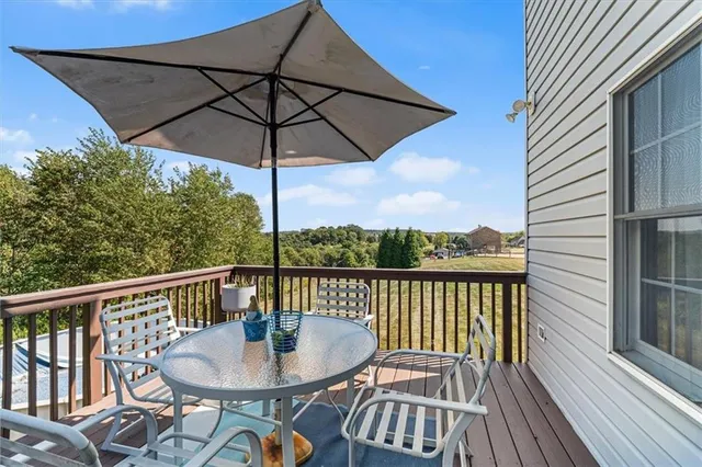 a view of a balcony with furniture and wooden floor