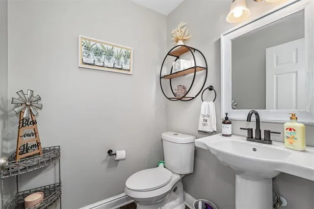 a bathroom with a toilet a sink and a mirror