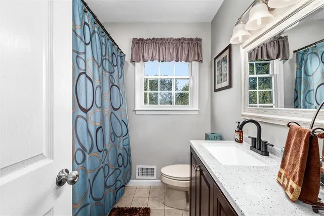 a bathroom with a granite countertop sink toilet and a mirror