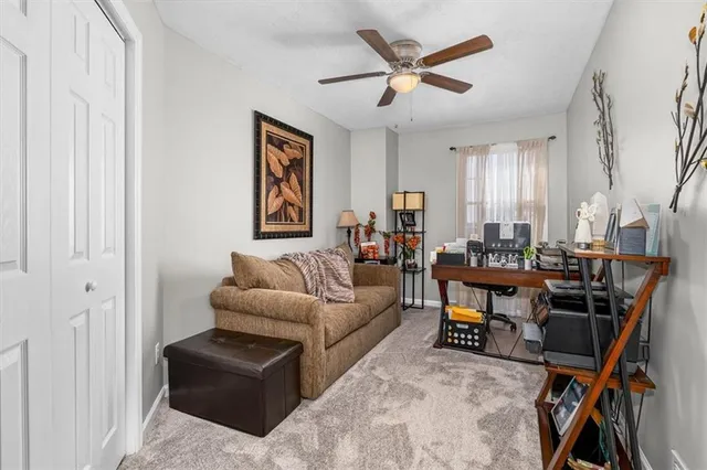 a living room with furniture a ceiling fan and a window