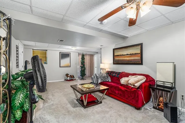 a living room with furniture ceiling fan and a potted plant