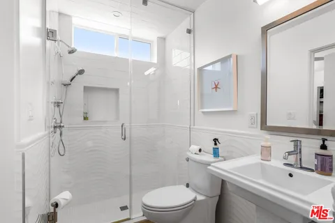 a bathroom with a sink a toilet and shower