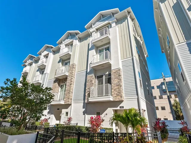 a front view of a multi story residential apartment building with yard