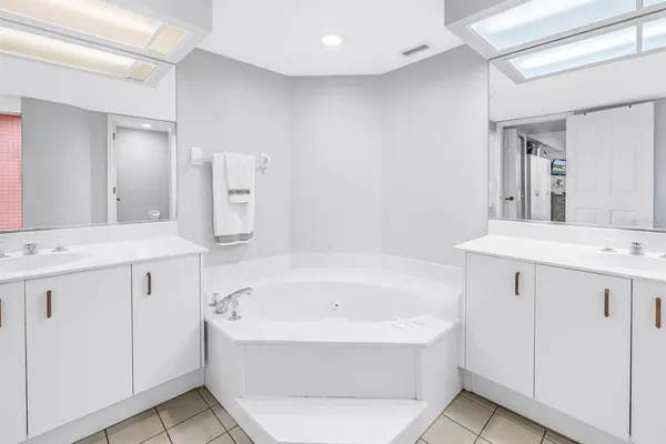 a bathroom with a bathtub a mirror a sink and vanity