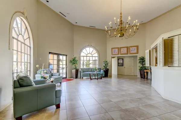 a living room with furniture a chandelier and a large window