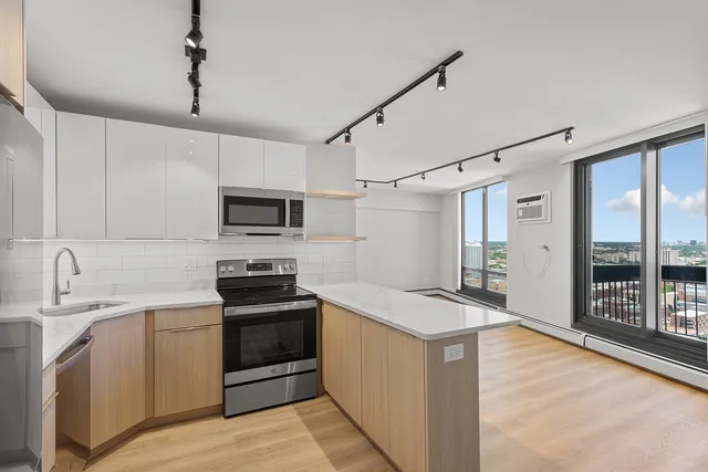 a kitchen with granite countertop a sink stove and refrigerator