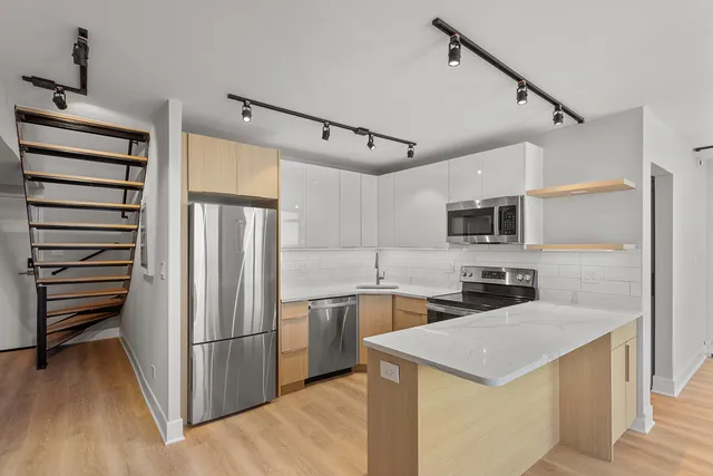 a kitchen with stainless steel appliances a refrigerator and a stove top oven