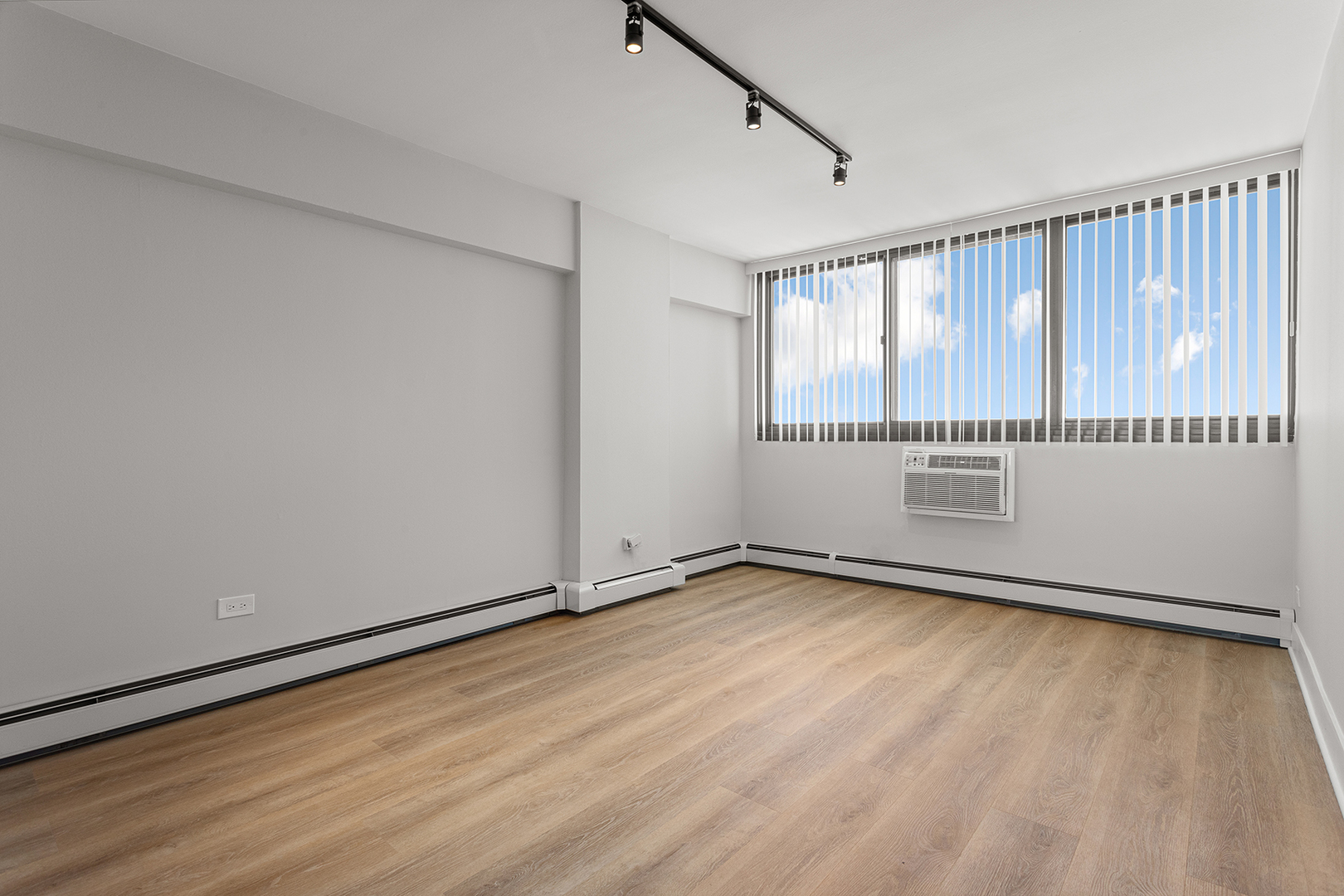 6166 North Sheridan Road, Unit 20C Chicago, IL 60660 - Photo 8 of 19 a view of an empty room with wooden floor and a window