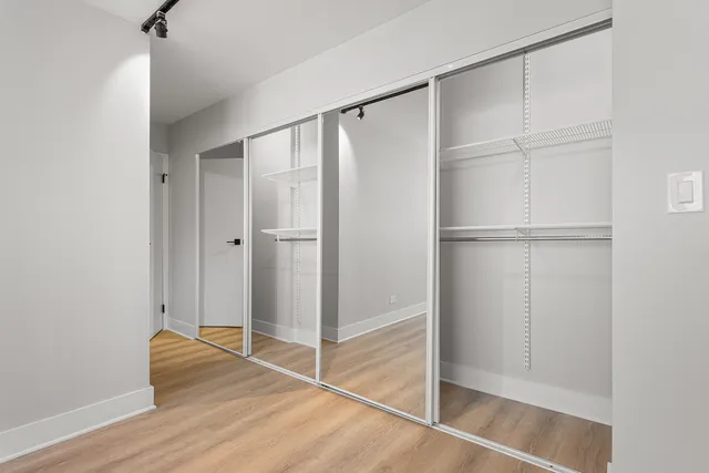 a room that has a glass door and wooden floor