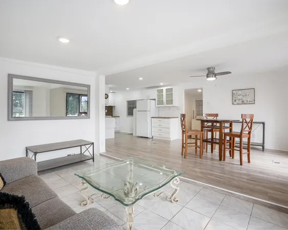 a living room with furniture and a dining table with kitchen view