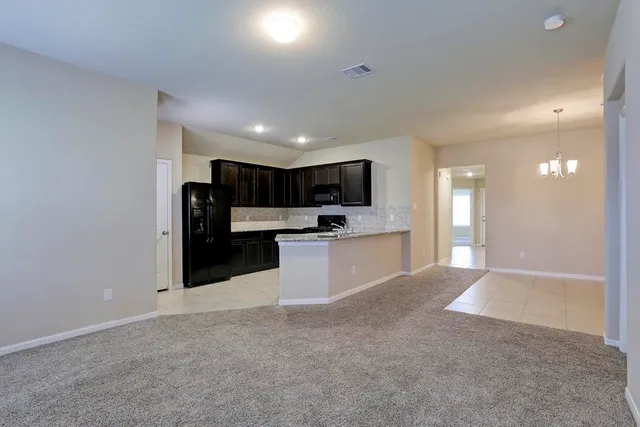a view of kitchen with refrigerator stove microwave and cabinets