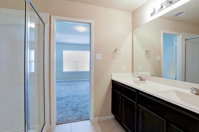 a bathroom with a double vanity sink and a mirror