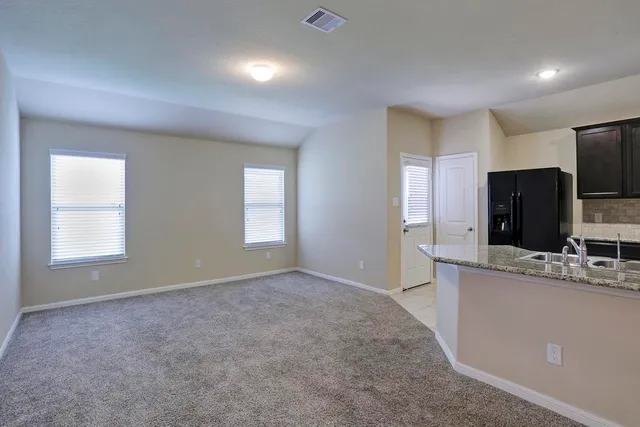 a view of a kitchen with a sink cabinet and a refrigerator