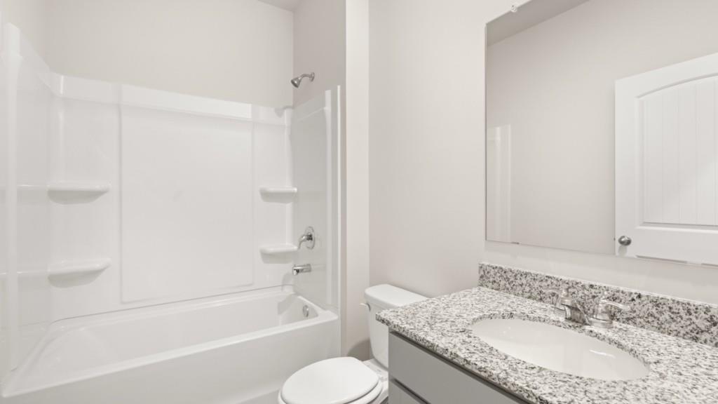 113 Crooked Lk Park Villa Rica, GA 30180 - Photo 12 of 30 a bathroom with a granite countertop sink toilet and shower