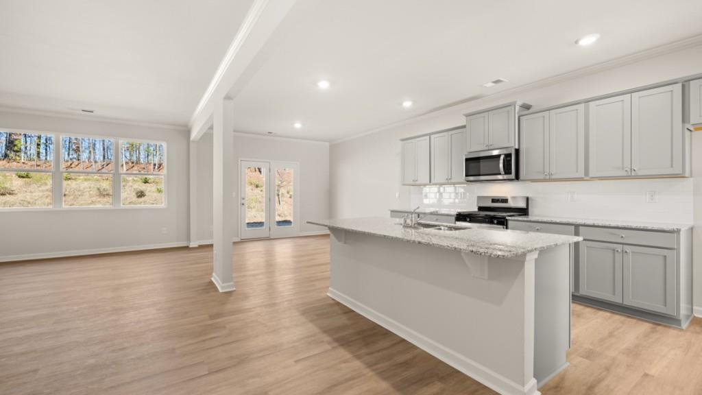 113 Crooked Lk Park Villa Rica, GA 30180 - Photo 4 of 30 a kitchen with stainless steel appliances a stove top oven a sink a refrigerator a microwave and cabinets