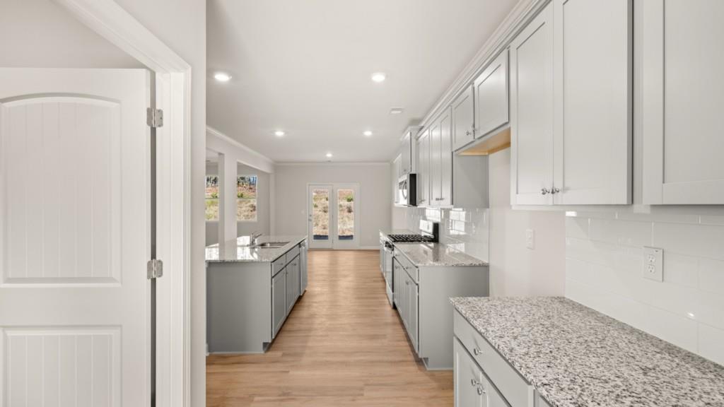 113 Crooked Lk Park Villa Rica, GA 30180 - Photo 6 of 30 a view of a kitchen with kitchen island wooden floor center island and stainless steel appliances