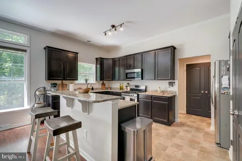 a kitchen with stainless steel appliances granite countertop a sink stove and cabinets