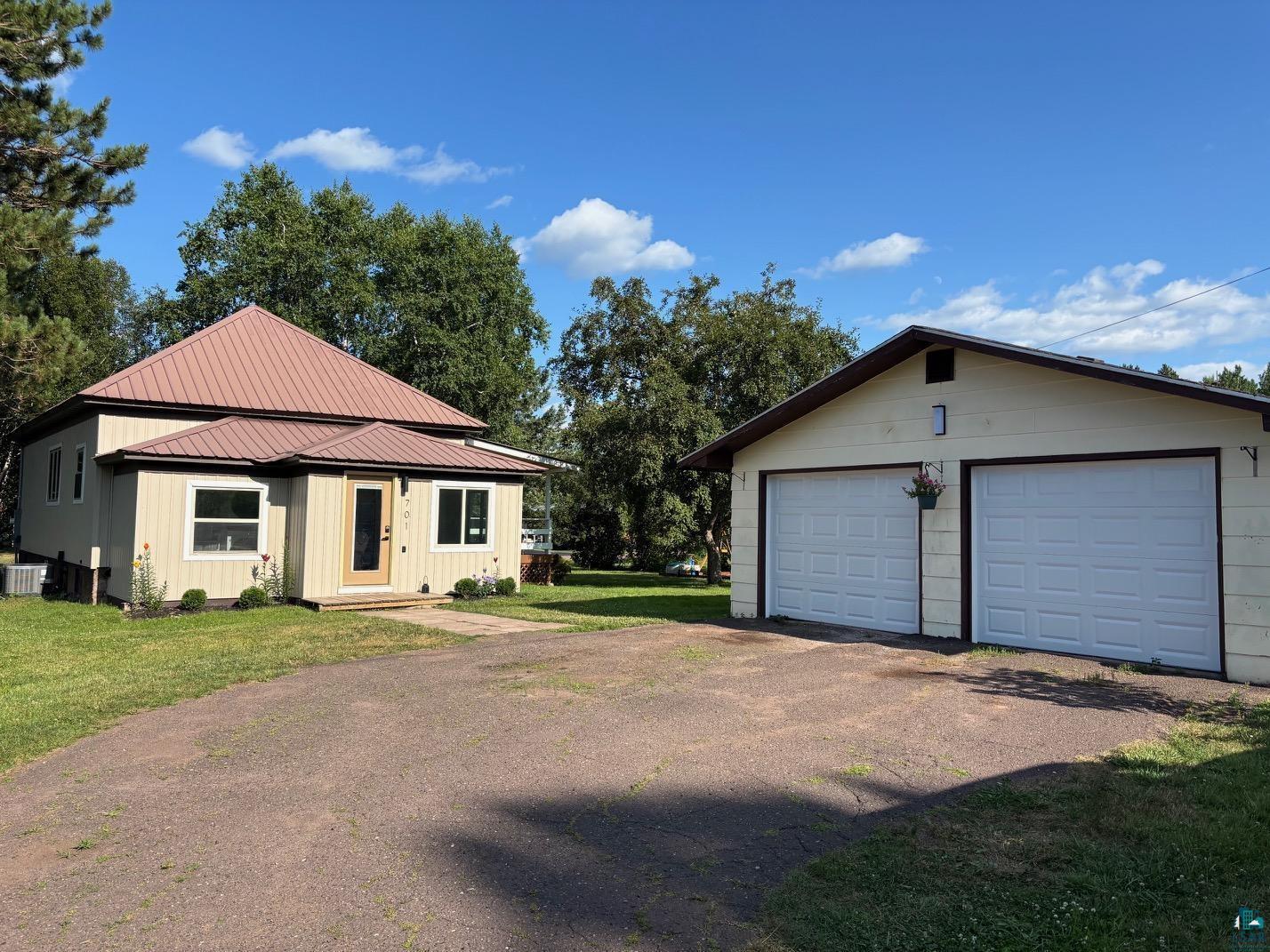 701 Drake Street Mellen, WI 54546 - Photo 27 of 27 Property featuring a detached two-car garage with white panel doors and a light-colored exterior