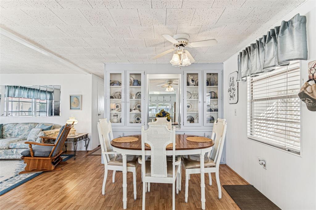 13225 101st Street Southeast, Unit 222 Largo, FL 33773 - Photo 12 of 73 a view of a dining room with furniture a chandelier and wooden floor