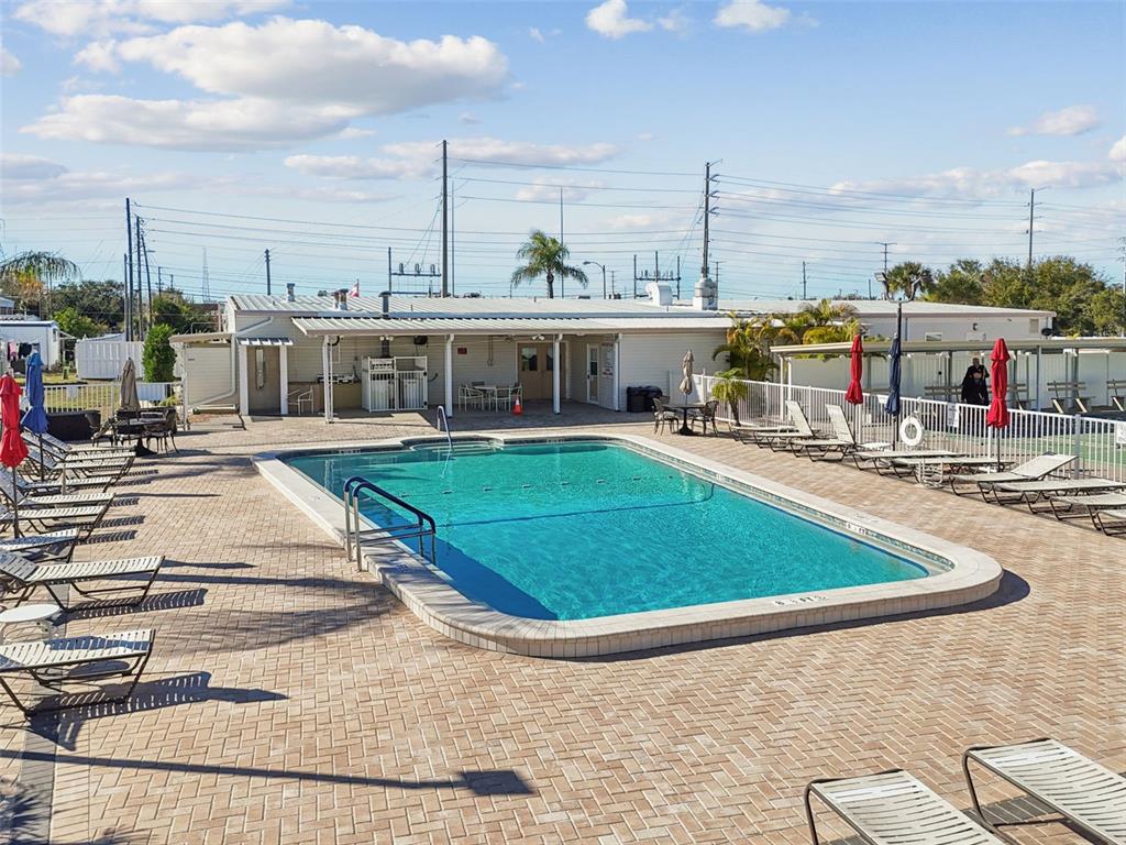 13225 101st Street Southeast, Unit 222 Largo, FL 33773 - Photo 68 of 73 a view of a swimming pool with lawn chairs and wooden fence
