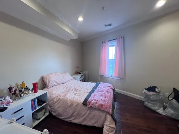 a bedroom with a bed and wooden floor