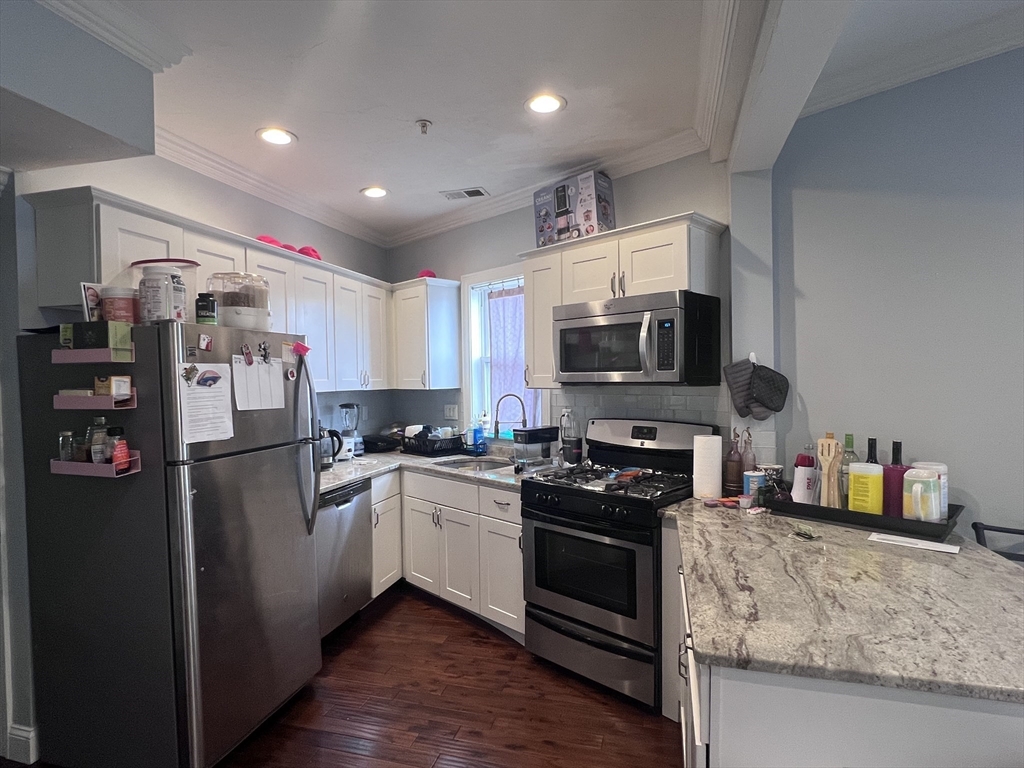 140 Marcella Street, Unit 4 Boston, MA 02119 - Photo 2 of 14 a kitchen with stainless steel appliances granite countertop a refrigerator stove top oven and sink