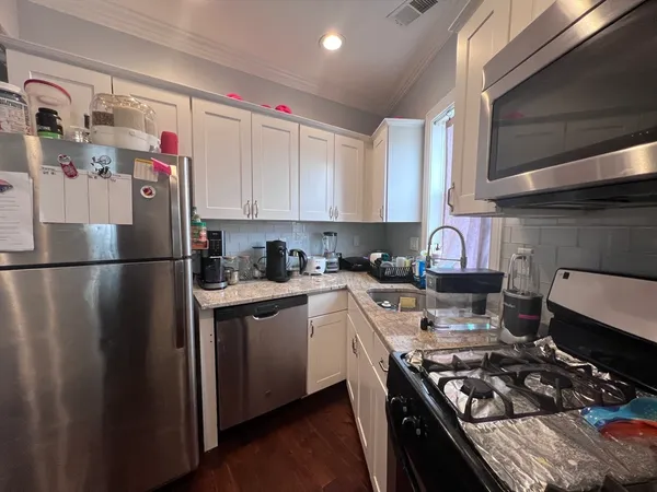 a kitchen with stainless steel appliances granite countertop a stove a sink dishwasher and a refrigerator