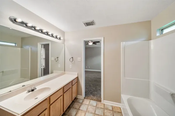 a spacious bathroom with a double vanity sink a mirror and a bathtub