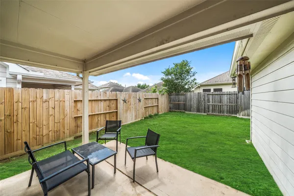 a view of a backyard with table and chairs and potted plants