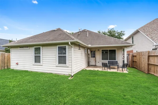 a view of a house with a backyard and chairs