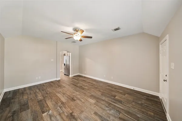 a view of an empty room with a chandelier fan