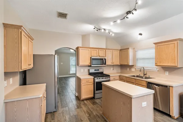 a kitchen that has a sink a stove and refrigerator