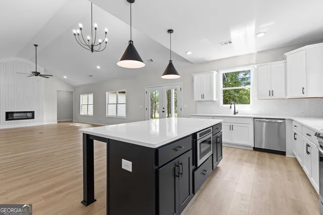 a kitchen with a stove sink and cabinets