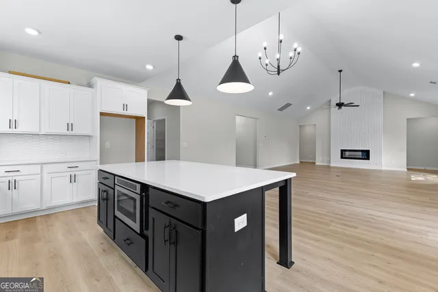 a kitchen with kitchen island a wooden floor and white appliances