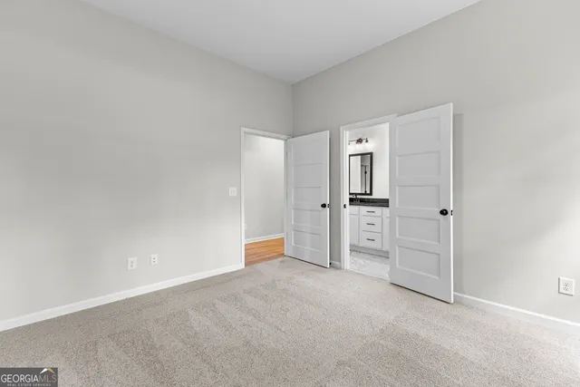 a white bath tub sitting next to a white toilet and wooden vanity