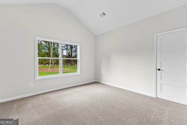 a view of an empty room with windows and a fireplace