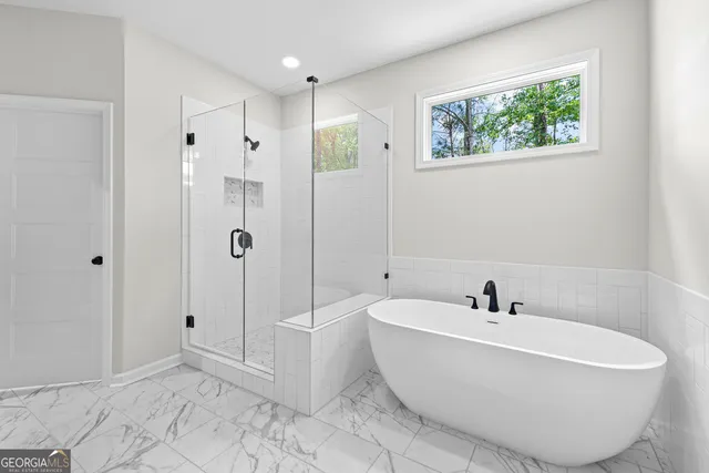 a bathroom with a tub shower and mirror