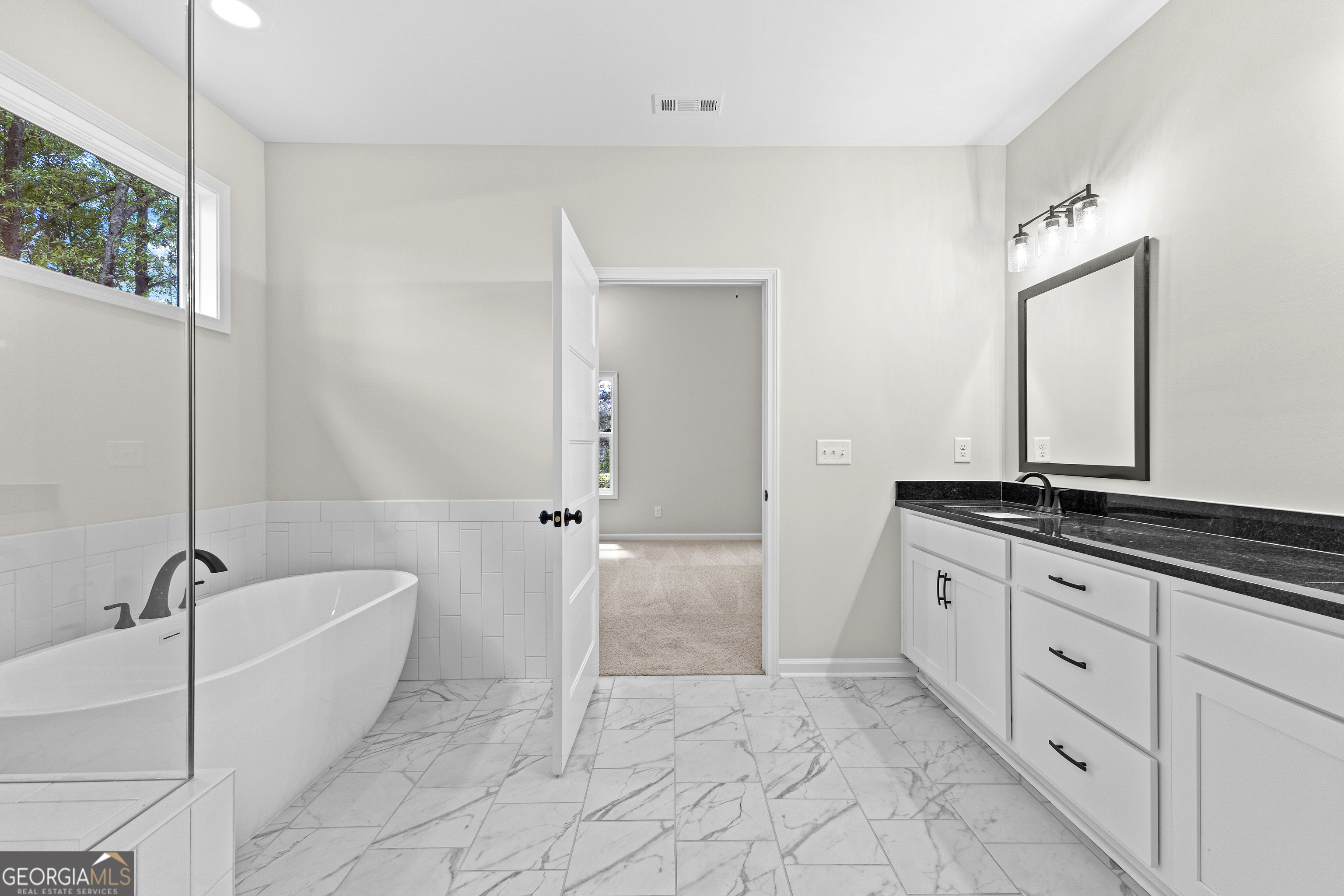 1210 Waymanville Road Thomaston, GA 30286 - Photo 40 of 45 a spacious bathroom with a granite countertop sink a mirror and a bathtub