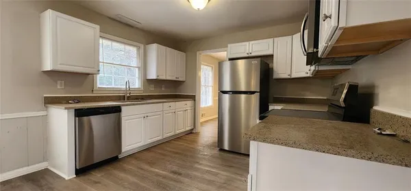 a kitchen with a refrigerator sink and stove top oven