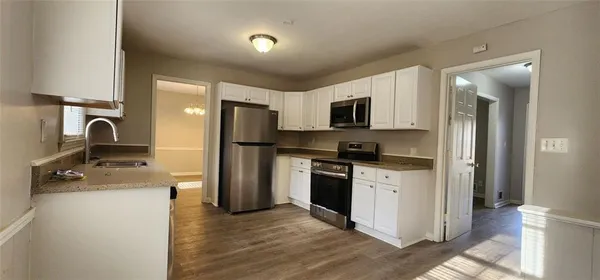 a kitchen with stainless steel appliances granite countertop a stove a microwave and a refrigerator