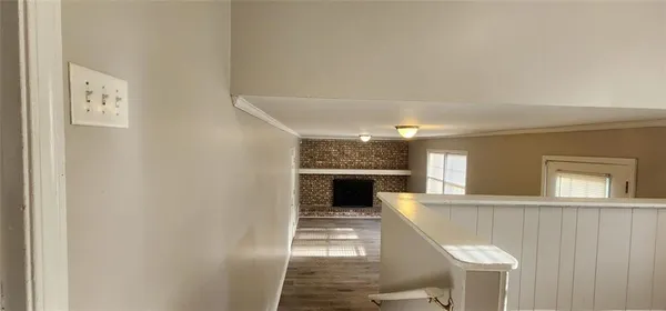 a view of a hallway with wooden floor and staircase