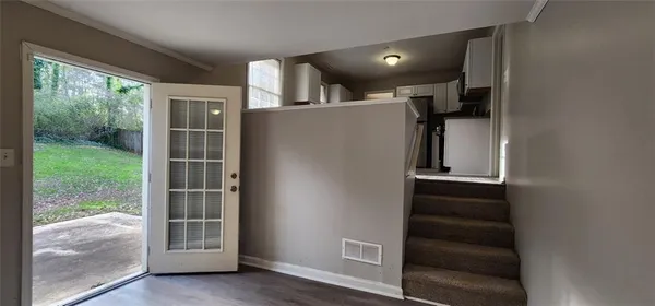 an empty room with wooden floor and windows