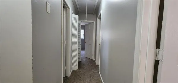 a view of an empty room with closet and a window