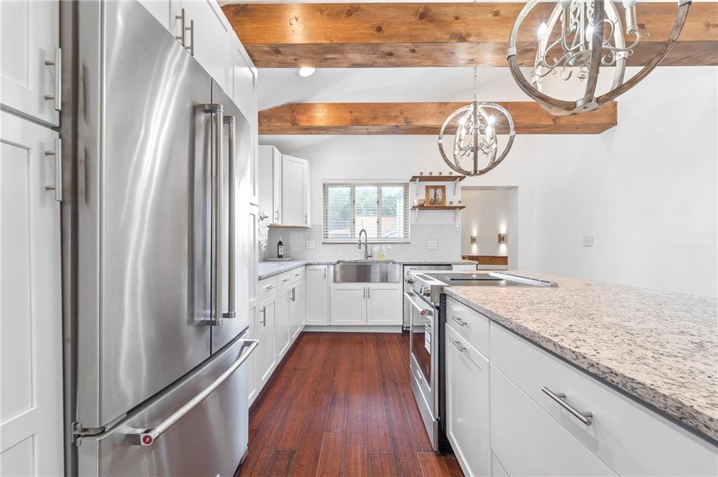 16 5th Street Carnegie, PA 15106 - Photo 6 of 31 an open kitchen with a wooden floor and a clock on wall