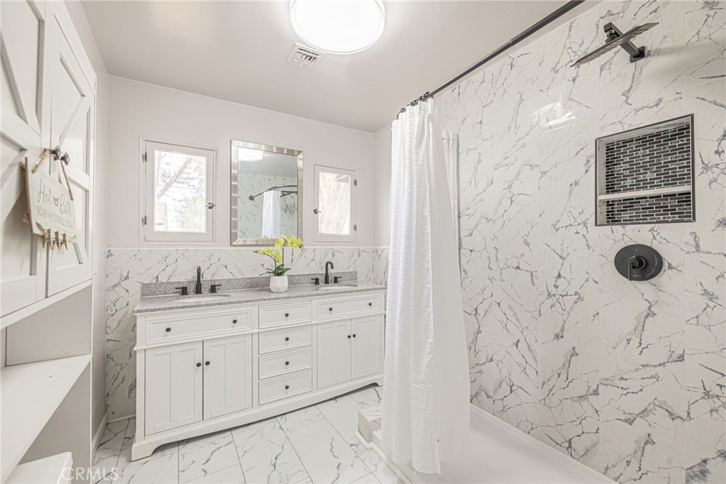 44603 Fig Avenue Lancaster, CA 93534 - Photo 25 of 39 a bathroom with a granite countertop sink a mirror a shower and a bathtub