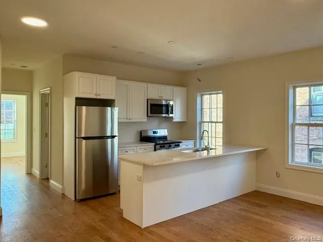 a kitchen with a refrigerator and a stove top oven