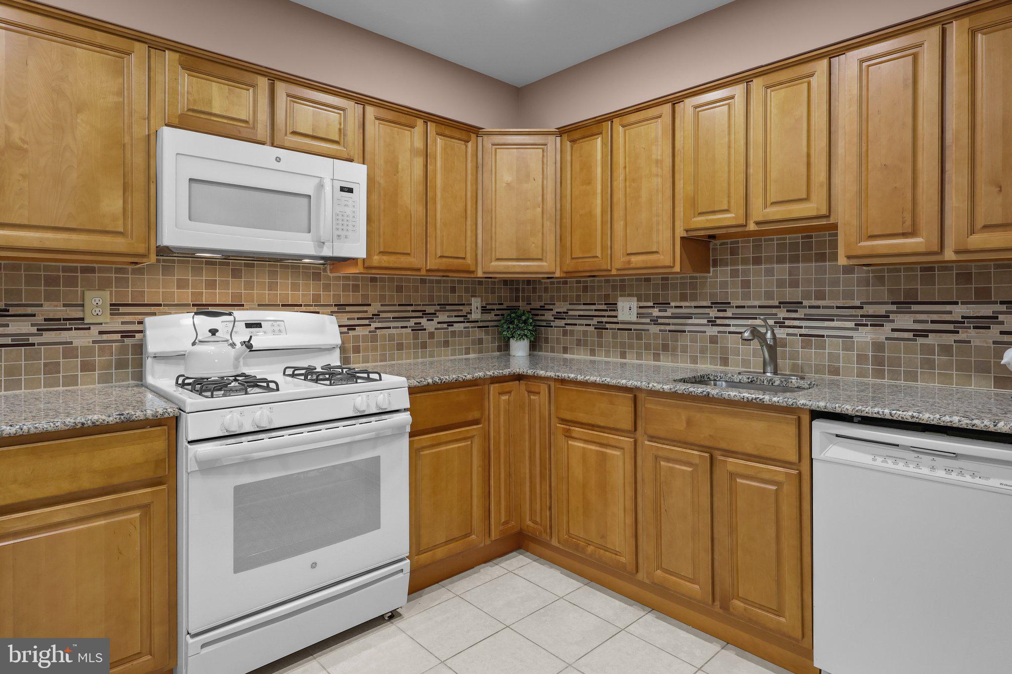 185 Greendale Road Philadelphia, PA 19154 - Photo 9 of 26 a kitchen with stainless steel appliances granite countertop a sink stove and cabinets