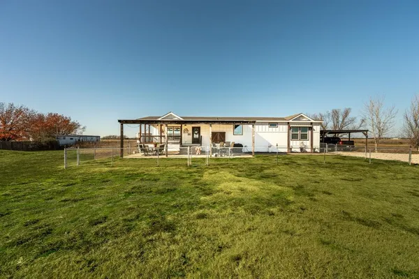 a front view of house with yard and lake view
