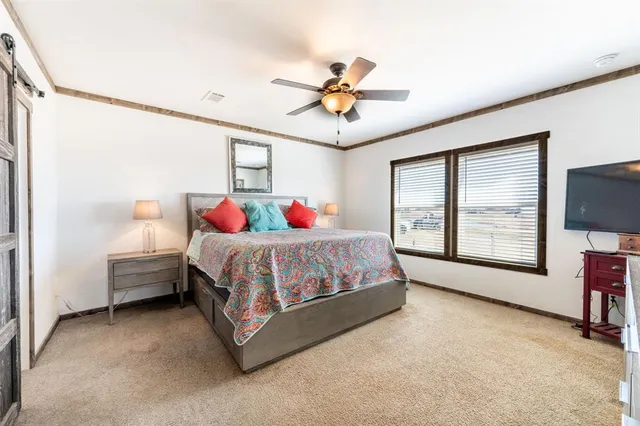 a bedroom with a bed chandelier and a window